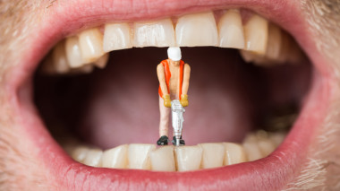 Spielzeug-Bauarbeiter mit Presslufthammer zwischen Zähnen
